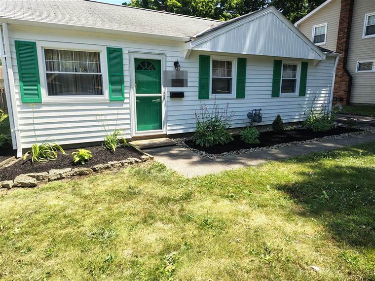 Finished front-yard flower beds with mulch and river rock