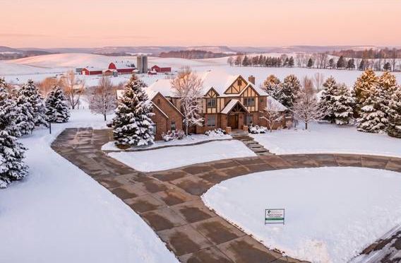Home with a long driveway after a snowfall